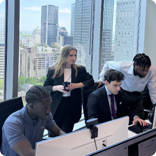 4 jeunes dans un bureau avec des buildings concentré sur une tâche collective
